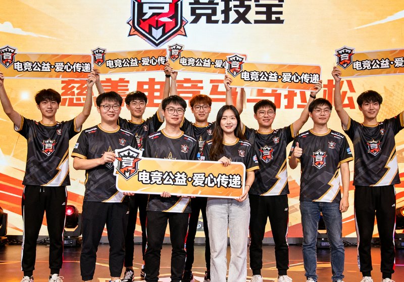 竞技宝赞助的慈善电竞马拉松活动现场，参与者举着公益标语牌在舞台上合影
